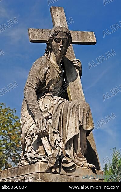 Statue of a woman carrying a cross on a 19th century family grave, Johannisfriedhof cemetery, founded in the 13th century, Brueckenstrasse street 9, Nuremberg, Middle Franconia, Bavaria, Germany, Europe.