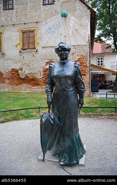 Sundial and bronze statue of a woman in 19th century dress carrying an umbrella at Tkalciceva ulica, Tkalciceva Street, Gornji Grad, Zagreb, Croatia, Europe.