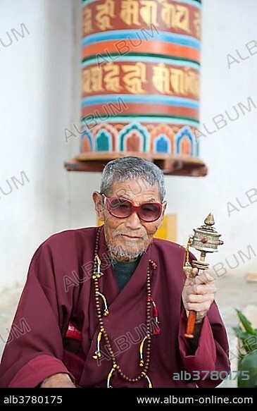 Tibetan Buddhism, believer with large sunglasses spinning a small prayer wheel, Thimphu, the Himalayas, Kingdom of Bhutan, South Asia, Asia.