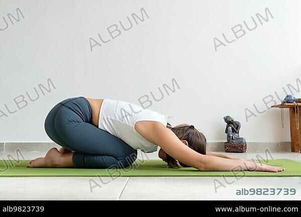 Young woman practicing yoga, Utatasana / Buddhist stupa pose Stock Photo |  Adobe Stock