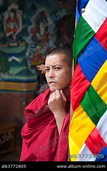 Tibetan Buddhism, monk wearing a red robe looking pensive, Rinpung Dzong Monastery and Fortress, Paro, Himalayas, Bhutan, South Asia, Asia.