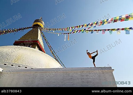 Young woman practicing yoga at Boudnanath stupa, showing the ...