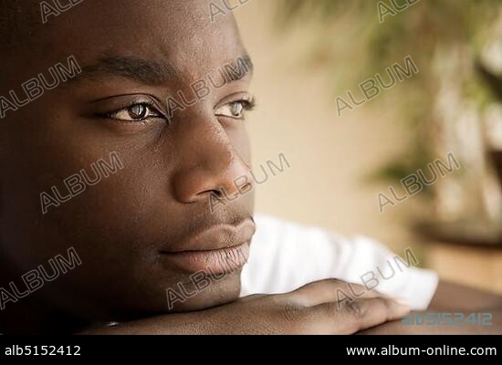 Dark-skinned, 15-year-old boy, faraway look in eyes.