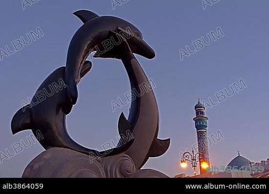 The dolphin statue and the minaret of the Rasool Azam Mosque, Muttrah, Muscat Governorate (Capital Area, Oman, Asia.