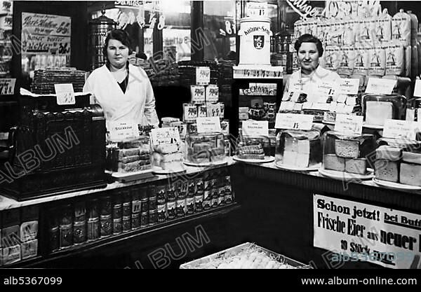 Two saleswomen standing behind the counter, historic picture from about 1910.