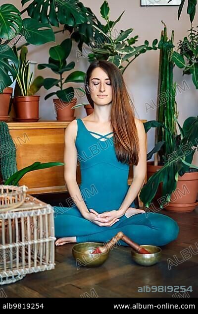 Young woman making yoga exercises and meditation. Fitness girl in