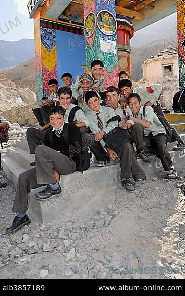 Students wearing uniforms in front of a prayer wheel in Hunder
