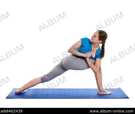 Woman with red colored yoga dress, posing yoga Natarajasana (lord of the  dance) on a green grasss background. Stock Photo