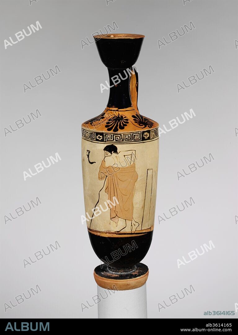 Terracotta lekythos (oil flask). Culture: Greek, Attic. Dimensions: H. 10 1/4 in. (26 cm). Date: 1st quarter of 5th century B.C..
Trainer
The young man is characterized as a trainer by the himation (overgarment) draped over his body and the staff on which he leans. The strigil (scraper) suspended before him and the column behind him indicate a setting for the training of athletes. The painter's artistic ambitions appear in the representation of the figure from the back.