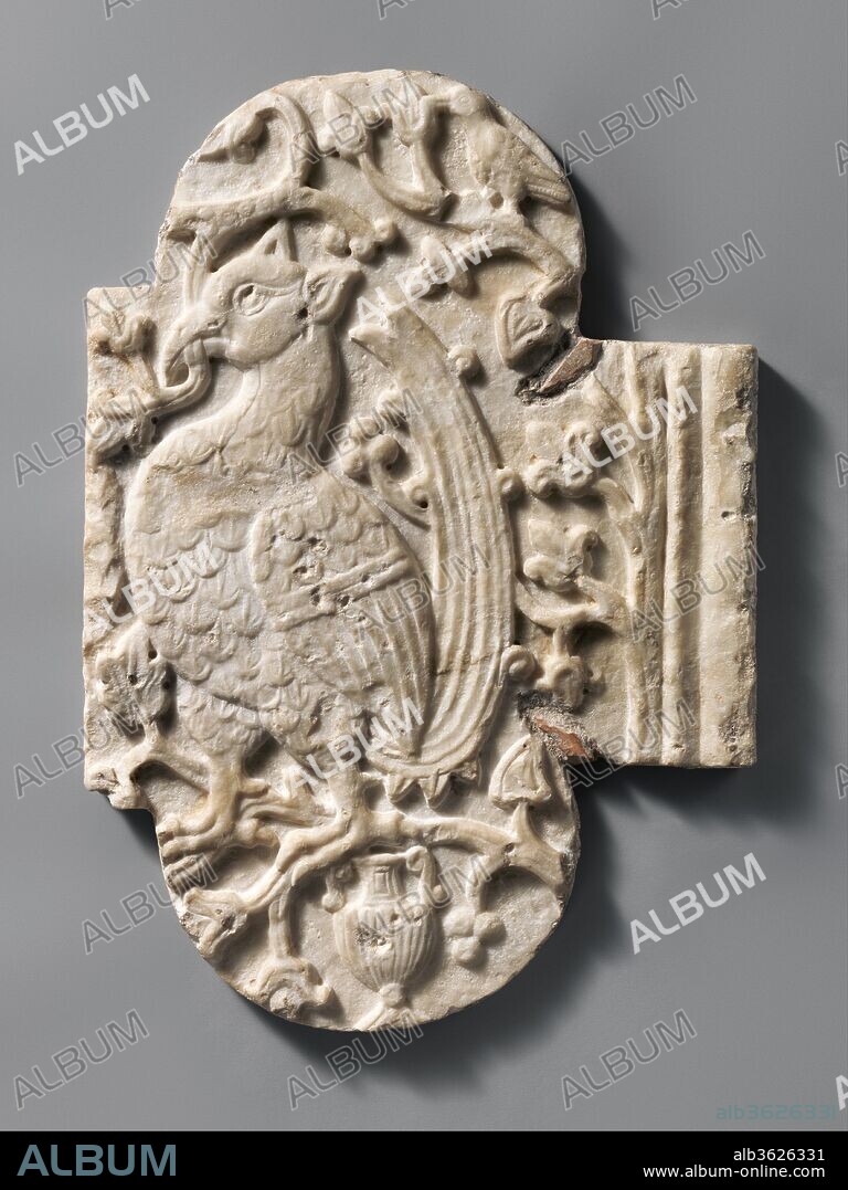 Relief with a Bird. Culture: Italian. Dimensions: Overall: 24 5/8 × 17 1/4 × 1 3/8 in., 30lb. (62.5 × 43.8 × 3.5 cm, 13.6kg). Date: 10th-11th century.
This relief,  cut down from a larger composition, shows an imaginary bird, a cock with a griffin-like head, set within foliage. It is from  Salerno, where it was said to have been built into the masonry of a church. It was reused at a later date, and cut into its present form.  While its original function is unknown, it may have been part of a chancel screen, a low wall in front of the sanctuary of a church.  The exotic and orientalizing bird reflects the rich interchange of design motifs between the Islamic, Sasanian, Byzantine, and south Italian cultures in the century around 1000.