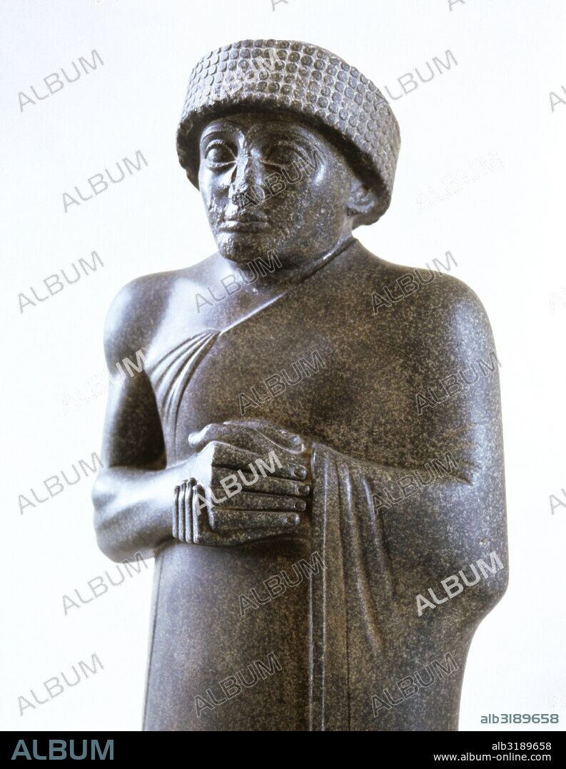 Estatua de GUDEA, Príncipe de Lagash. Escultura realizada en diorita del periodo Neo-sumerio. Representación de pie con el manto sumeriano que deja su hombro derecho al descubierto y con la cabeza cubierta por turbante. Hallada en Girsu, actual Tello o Tel Telloh (Iraq). Museo del Louvre. París. Francia.