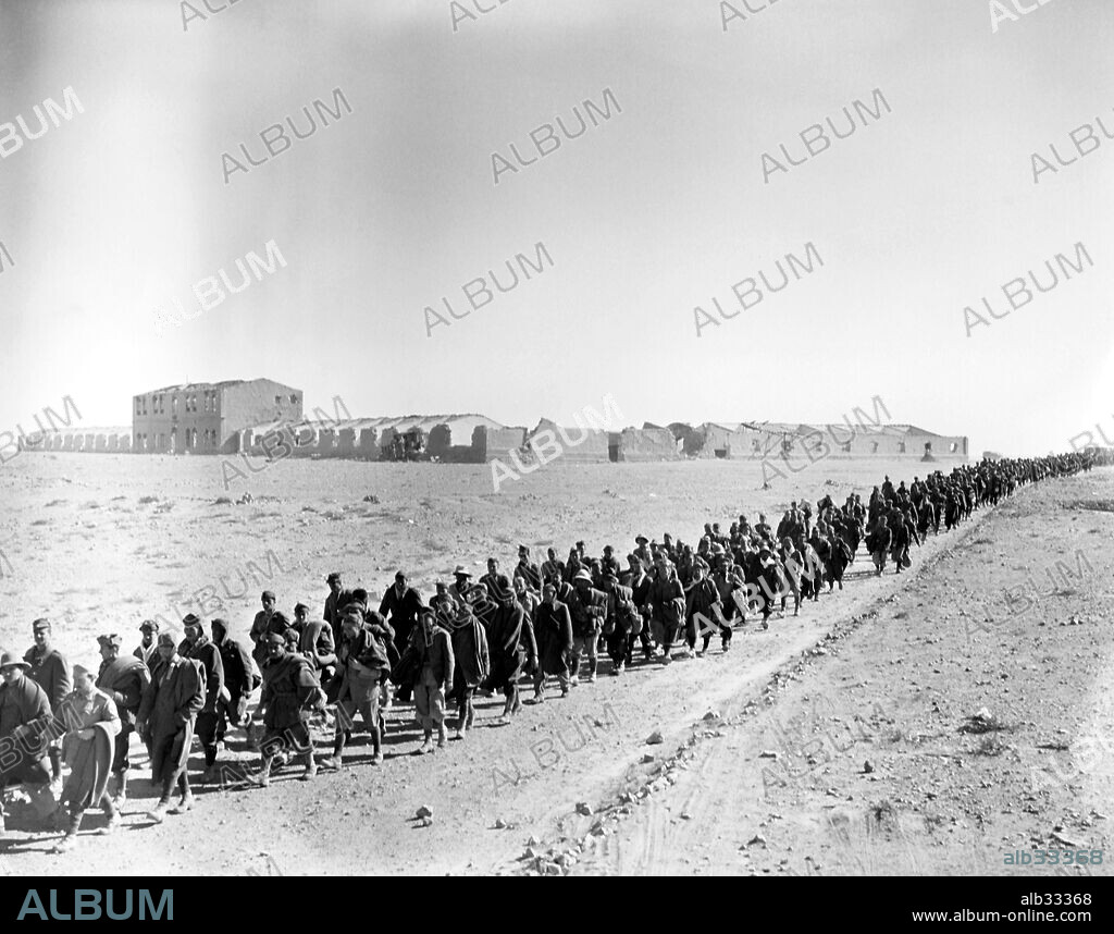 Masses of italian prisoners being marched back, in some cases with only one soldier guard. The ruins in the background are those of Egypt's village Sidi Barrani.