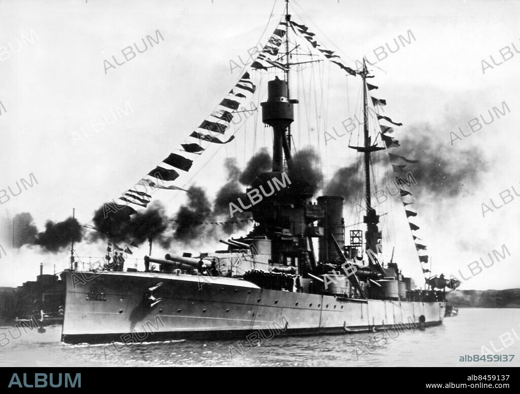 ESTLAND TALLINN 1917.. Utan bildtext. Not. Battleship Sverige in harbour of Reval where it brought the Swedish King. Anm. Pansarskeppet Sverige stapelsattes på Götaverken i GBG 1912, sjösattes den 3 maj 1915 och levererades till flottan 1917. Data: 7080 ton längd 117,9m bredd 18,6m djupgående 6,8m Beväpning: 4x283, 8x15,2cm 4x7,5cm, 4x40mm och 4x45cm TT Pansar: vattenlinje 200mm, torn180mm, däck 20mm Fart: 22,5 knop. Sverigeskeppen de så kallade F-båtarna var förutom Sverige, Drottning Victoria (Göta Verken i Göteborg) och Gustav V. (Kockums i Malmö) Alla tre moderniserades under 20, 30, 40-talet. De var kvar i flottan en bit in på femtiotalet innan de skrotades. Bilden är från Svenska kungens officiella besök i Estland 1917. Pansarskepp. persons: GUSTAF V, KUNG AV SVERIGE sites: ESTLAND;SVERIGE*;TALLINN;BALTIKUM.