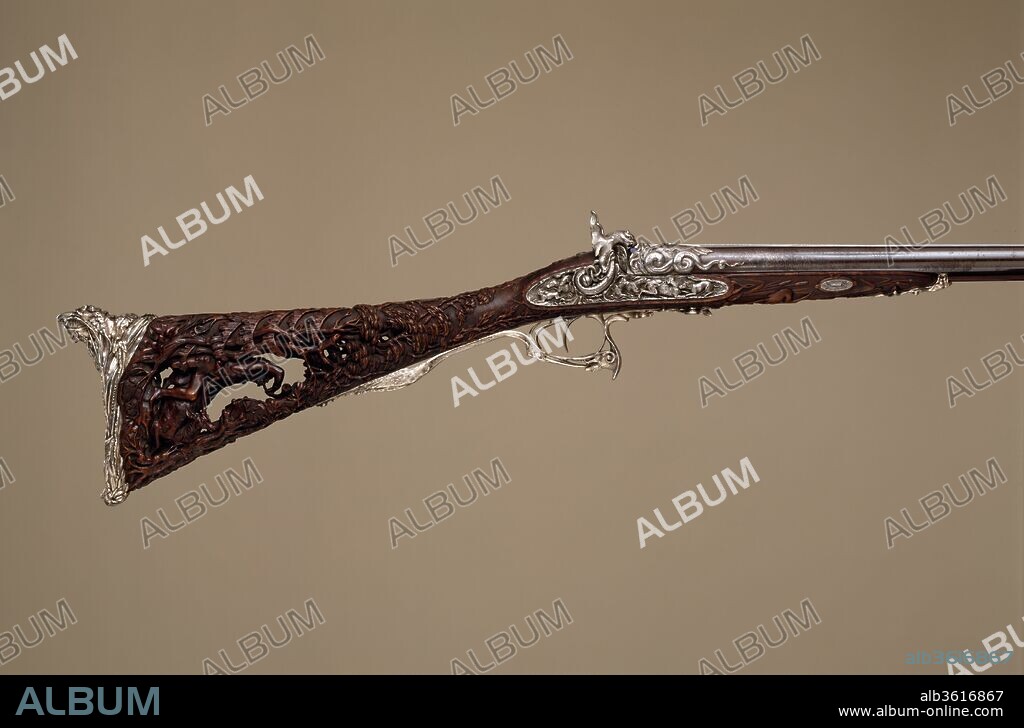 Double-Barreled Percussion Shotgun. Barrelsmith: Léopold Bernard (French, Paris, active 1832-70). Culture: French, Paris. Dimensions: L. 46 3/5 in. (118.4 cm); L. of barrel 29 1/8 in. (73.9 cm). Gunsmith: Louis Perrin (French, Paris, active 1823-65). Date: dated 1854.
This is presumably the "richly decorated gun" said to have been exhibited by Perrin in 1855 at the Exposition Universelle in Paris and again in 1862 at the International Exhibition in London. Undoubtedly Louis Perrin's masterpiece, this shotgun is one of the most ambitious firearms of its period. The butt, pierced and carved in the round with the figure of a medieval hunter, reflects the lingering influence of the Gothic revival. The silver mounts are of extraordinary quality, notably the buttplate with its graceful figure of a Native American.