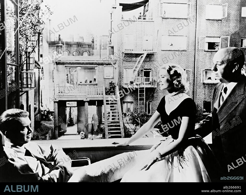 ALFRED HITCHCOCK, GRACE KELLY und JAMES STEWART in REAR WINDOW, 1954, unter der Regie von ALFRED HITCHCOCK. Copyright PARAMOUNT PICTURES.