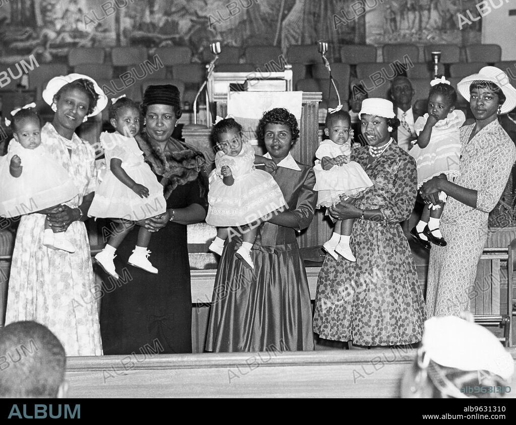 United States, c 1950 Five African American women holding their babies at an indoor gathering.