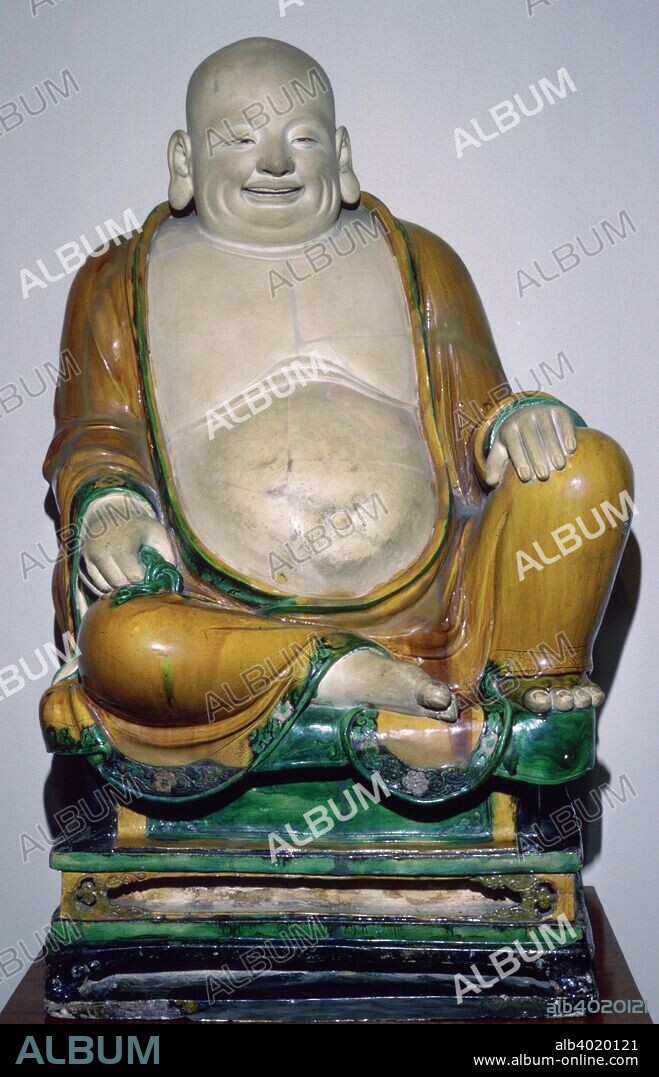 Ming Dynasty stoneware figure of Budai, the smiling monk and future Buddha. Ming Dynasty, from the reign of Changhua. Glazed with green and ochre, 15th century.