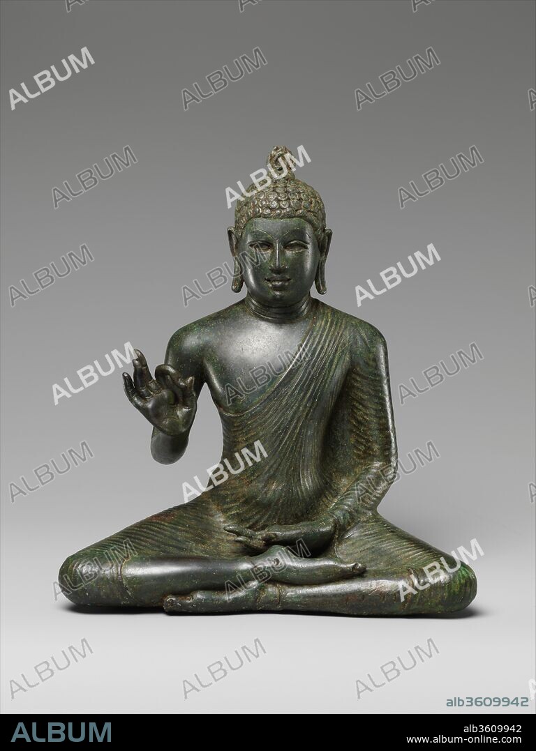 Buddha Expounding the Dharma. Culture: Sri Lanka (Anuradhapura). Dimensions: H. 10 1/2 in. (26.7 cm); W. 11 in. (7.9 cm); D. 4 1/2 in. (11.4 cm). Date: late 8th century.
The quintessential icon of early Buddhist Sri Lanka is the Buddha gesturing vitarka-mudra, imparting his dharma to all. Seated in a meditative yogic posture, he wears the monk's uttarasanga, an untailored length of cloth drawn tautly around the body, with his right shoulder exposed in the southern manner of Buddhism. His hair is expressed in short, tight curls to evoke his renunciation of the material world, when he cut off his hair and gave away his princely adornments. The eye sockets were inlaid with precious stones or rock crystal to add a heightened level of realism. The flame-shaped head protuberance (ushniha) is one of the principal auspicious markings (lakshanas) of Buddhahood.