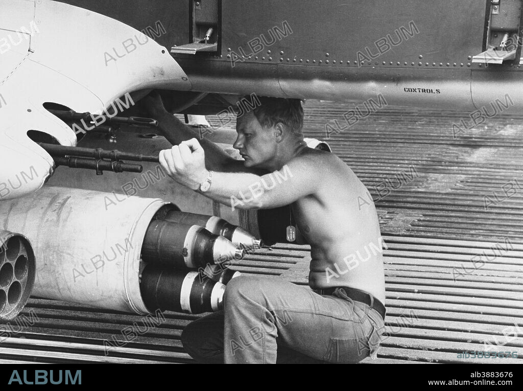 June 1969 - Aviation Machinist Mate Airman drains a fuel sample from an OV-10A Bronco reconnaissance aircraft of U.S. Navy Light Attack Squadron Four (VAL-4), at Vung Tau Air Base, Republic of Vietnam, June 1969. He left hand is holding the muzzle of one of the plane's four 7.62mm M60 machine guns. Immediately below is a pod of four Zuni 5-inch Folding-Fin Aircraft Rockets (FFAR). The front of a pod of seven 2.75-inch FFARs is at the extreme lower left.