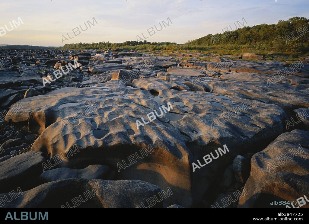 A dry spell reveals potholes beginning to form on the rocky bed of the Susquehanna River, Lancaster County, Pennsylvania (summer).