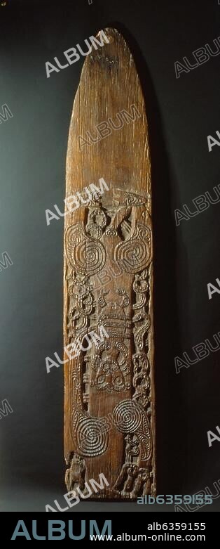 Pohu, or war gong, fashioned from a hollow tree, leaving a suspended tongue of plain wood at the base to be struck. It is decorated with a male figure (head missing), holding a female child. Country of Origin: New Zealand. Culture: Maori. Material Size: Wood.