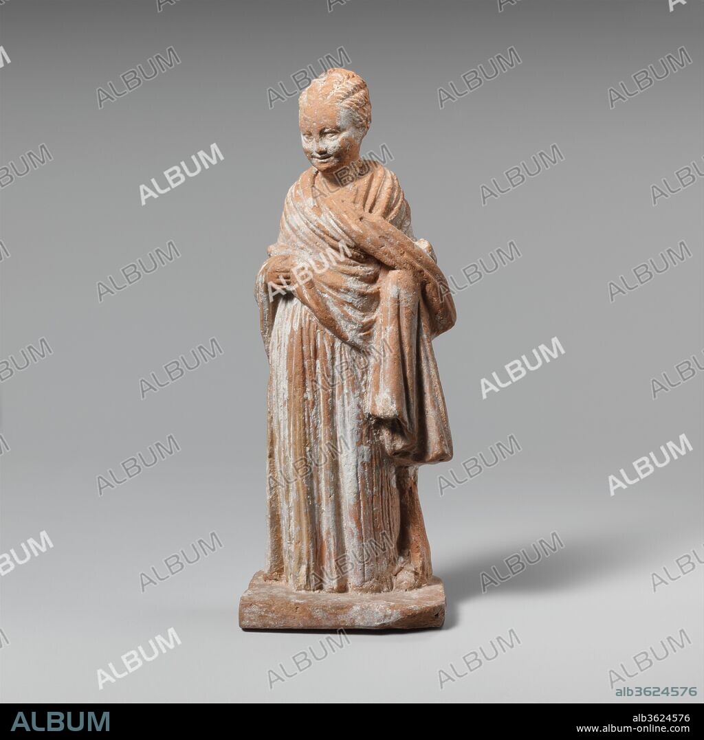 Terracotta statuette of a standing girl. Culture: Greek, Attic. Dimensions: Overall: 4 1/2 x 1 3/4 x 1 1/16 in. (11.4 x 4.4 x 2.6 cm). Date: ca. 300 B.C..
By the late fourth century B.C., children were no longer represented as miniature adults but rather were given childlike proportions and features.  This little girl is dressed like a grown-up in a chiton and a himation (cloak) wrapped around her upper body.  Her hair is in the twisted rolls of the so-called melon coiffure that was fashionable for ladies.  The carefully detailed drapery folds with varying thickness and depth resemble metalwork and mark this as an early figurine from the sophisticated workshops of Athens itself, where this type of figurine was first developed.