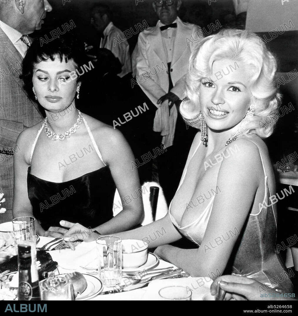 JAYNE MANSFIELD y SOPHIA LOREN. American actress and model Jayne Mansfield, known for her publicity stunts, attended a dinner at the exclusive Beverly Hills Romanoff's restaurant hosted by Paramount Pictures to officially welcome Italian actress Sophia Loren to Hollywood. A photograph of the two women, with Loren casting a sideways glance at Mansfield's cleavage, was distributed world-wide and became an international sensation.