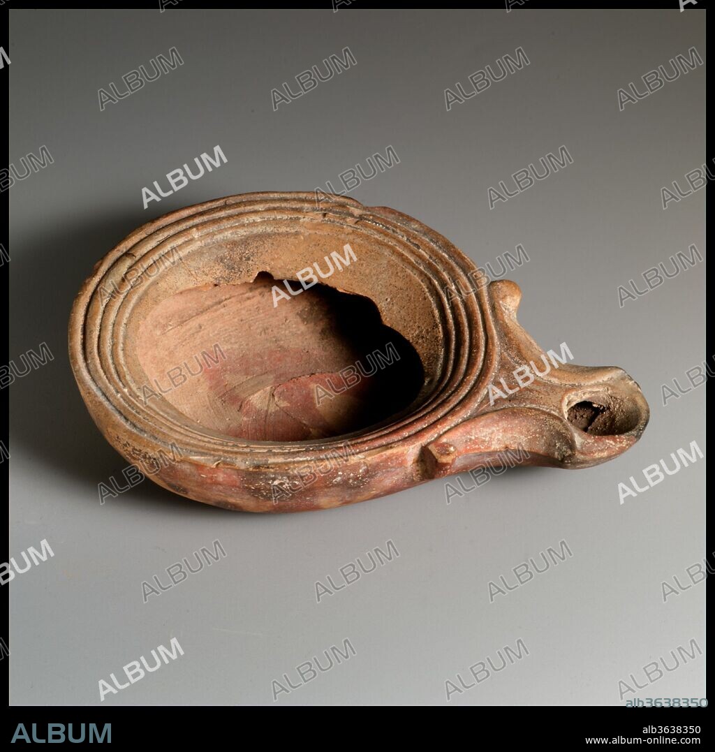 Terracotta oil lamp. Culture: Roman, Cypriot. Dimensions: Overall: 1 1/8 x 4 1/4 in. (2.9 x 10.8 cm).
Loeschcke Type 1A. Mold-made. Discus: unknown, with a band of lines and grooves at edge. Volutes flanking nozzle. Within raised, broad base ring, slightly concave base, with impressed letters: FVASI, and X below.
Most of discus missing, but body and nozzle complete.