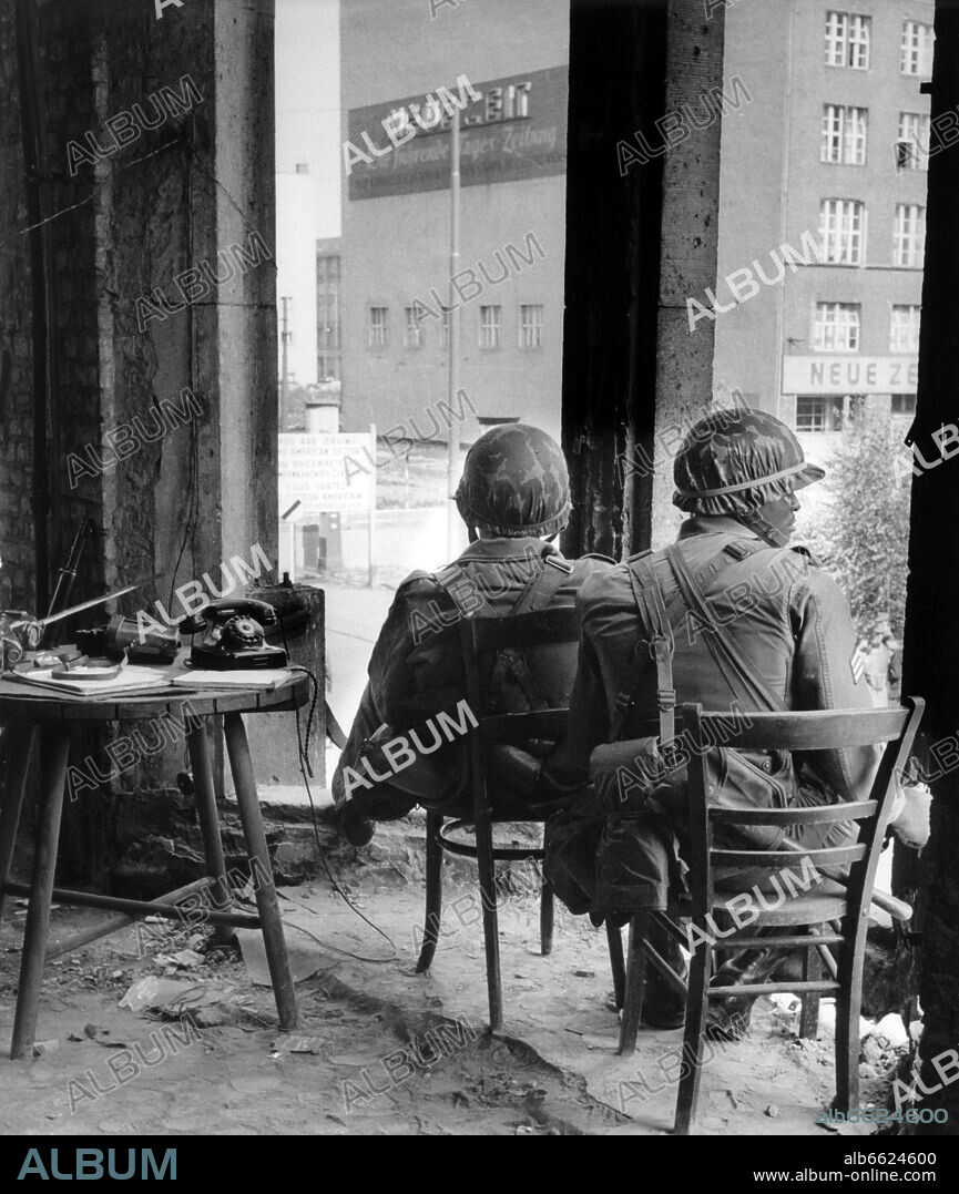 Soldiers of the US army sitting in a ruin on Friedrichstraße in West Berlin and keeping guard at the sector border at the eastern part of city on 29th August 1961. From 13th August 1961, the day of the building of the wall, until the fall of Berlin Wall on 9th November 1989 the Federal Republic of Germany and the GDR were split by the 'iron curtain' between west and east. 29/08/1961