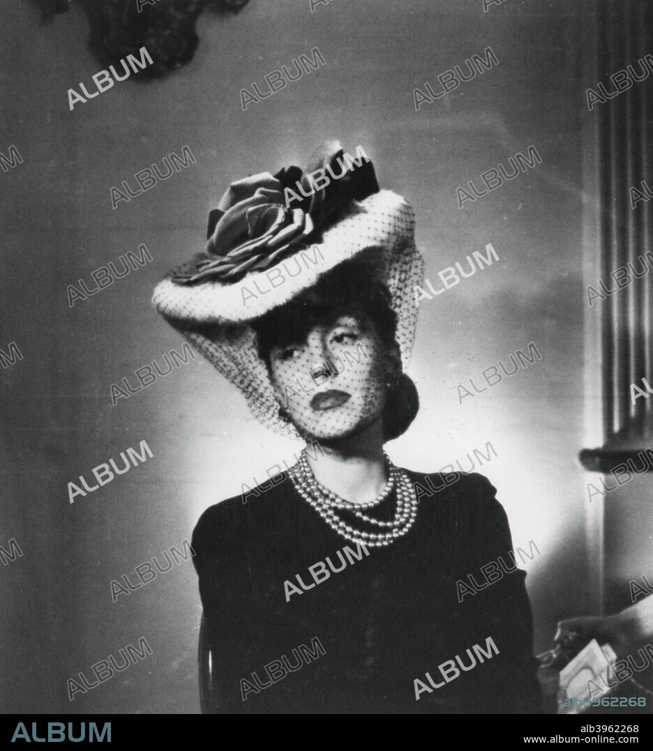 Woman wearing a hat and veil by the French fashion designer Jacques ...