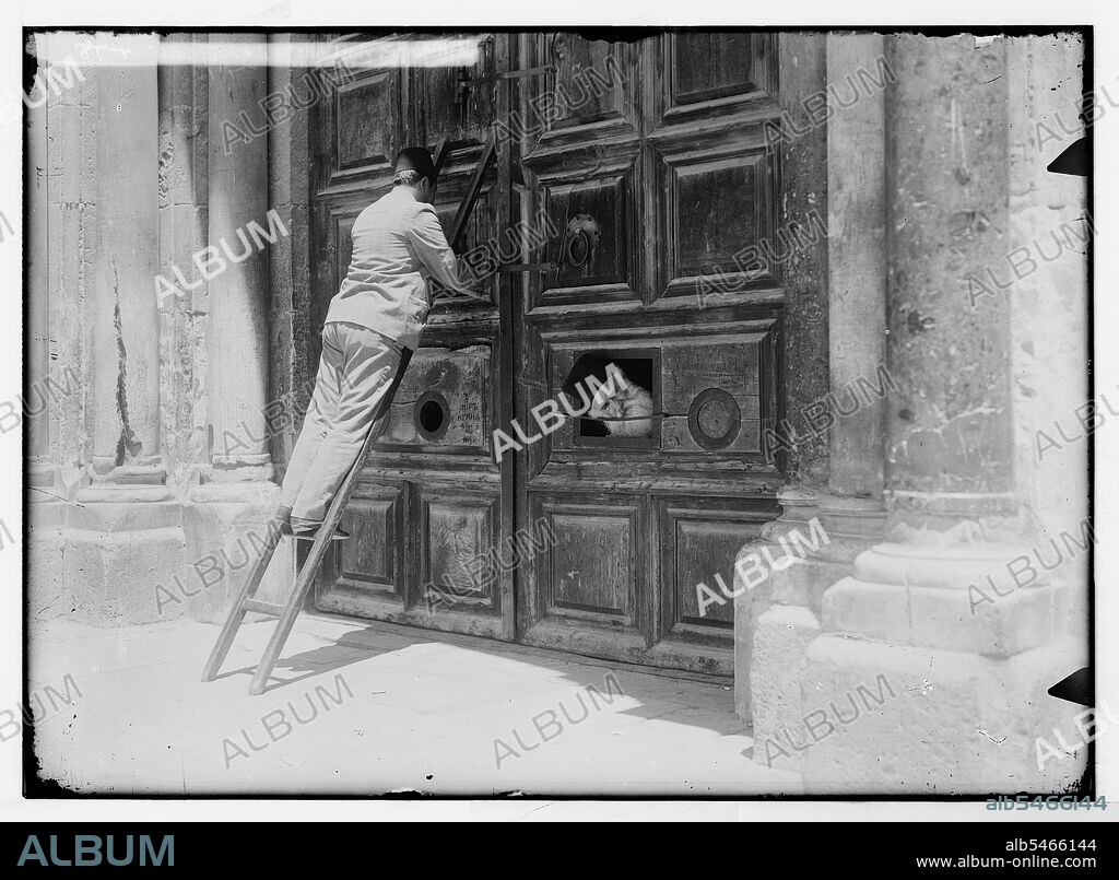 A man on a ladder is locking the locking the Church of the Holy ...