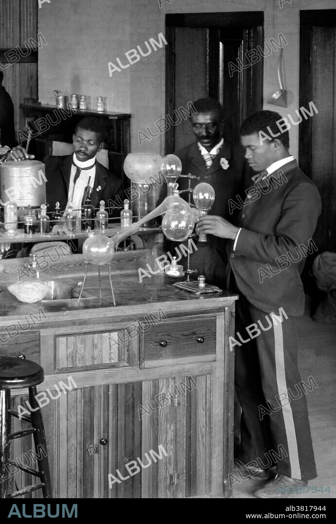 Chemistry laboratory/classroom with students at the Tuskegee Institute, Tuskegee, Alabama. George Washington Carver stands second from right, facing front (framed by doorway). George Washington Carver (1864 - January 5, 1943) was an African-American scientist, botanist, educator, and inventor born into slavery. In 1891 he attended and studied botany at Iowa State Agricultural College where he was the first black student, and later taught as the first black faculty member. His reputation is based on his research into and promotion of alternative crops to cotton, such as peanuts, soybeans and sweet potatoes, which also aided nutrition for farm families. He wanted poor farmers to grow alternative crops both as a source of their own food and as a source of other products to improve their quality of life. As an agricultural chemist, Carver discovered three hundred uses for peanuts and hundreds more for soybeans, pecans and sweet potatoes. He died in 1943, at the age of 78. In 1977, he was elected to the Hall of Fame for Great Americans. In 1990, he was inducted into the National Inventors Hall of Fame. Carver is often referred to as "Father of Chemurgy". Photographed by Frances Benjamin Johnston, 1902.