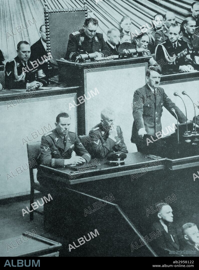 Photograph of a meeting of the Reichstag in the Kroll Opera House. Adolf Hitler is seen her justifying his actions against Poland. Sat next to Hitler is Hermann Göring who was named his successor. Dated 1939.