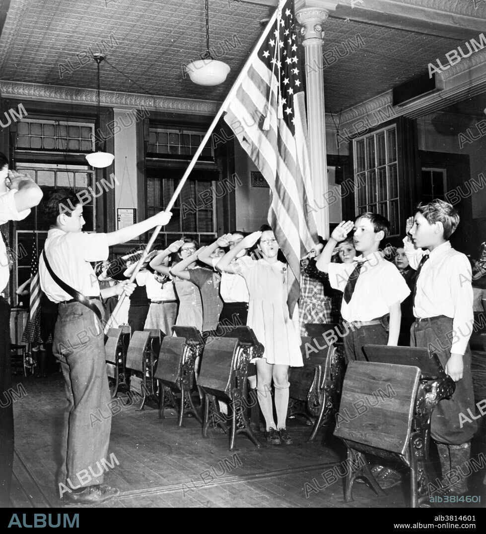 Students pledging allegiance to the flag in PS 8, an Italian-American section of NYC, photographed by Marjory Collins, January 1943. The Pledge of Allegiance is a solemn vow of loyalty and support for the country. "I pledge allegiance to the flag of the United States of America, and to the republic for which it stands, one nation under God, indivisible, with liberty and justice for all." The Pledge of Allegiance first appeared in 1892 in a children's magazine. The phrase under God, added in 1954, has inspired heated debate over the separation of church and state. Swearing of the Pledge is accompanied by a salute. An early version of the salute, adopted in 1892, was known as the Bellamy salute. It started with the hand outstretched toward the flag, palm down, and ended with the palm up. Because of the similarity between the Bellamy salute and the Nazi salute, developed later, the United States Congress instituted the hand-over-the-heart gesture as the salute to be rendered by civilians during the Pledge of Allegiance and the national anthem in the United States, instead of the Bellamy salute. Removal of the Bellamy salute occurred on December 22, 1942, when Congress amended the Flag Code language first passed into law on June 22, 1942.