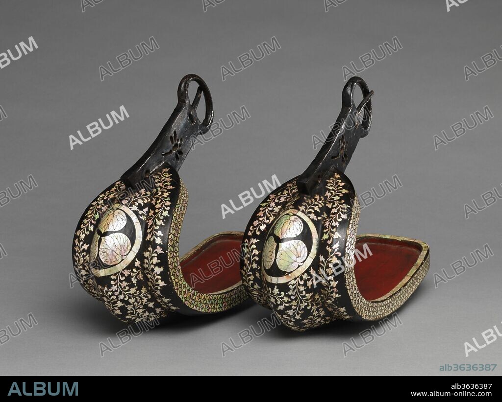 Pair of Stirrups (Abumi). Culture: Japanese. Dimensions: L. of each 11 3/4 in (29.8 cm); H. of each 10 3/8 in. (26.5 cm); W. of each 4 7/8 in. (12.5 cm). Date: late 16th-early 17th century.
Stirrups decorated with mother-of-pearl are rare, and this pair is perhaps the finest surviving example. Prominently placed on the front of each stirrup is a <i>mon</i> (heraldic emblem) consisting of three hollyhock leaves in a circle signifying the ownership of the Tokugawa family, which held the office of <i>shogun</i> (supreme military commander of Japan) from 1603 to 1868. At the time these stirrups were made, luxurious objects displaying the Tokugawa <i>mon</i> so prominently would have been appropriate only for Ieyasu Tokugawa, his son Hidetada Tokugawa (the first and second shoguns, respectively), or one of their closest relatives.