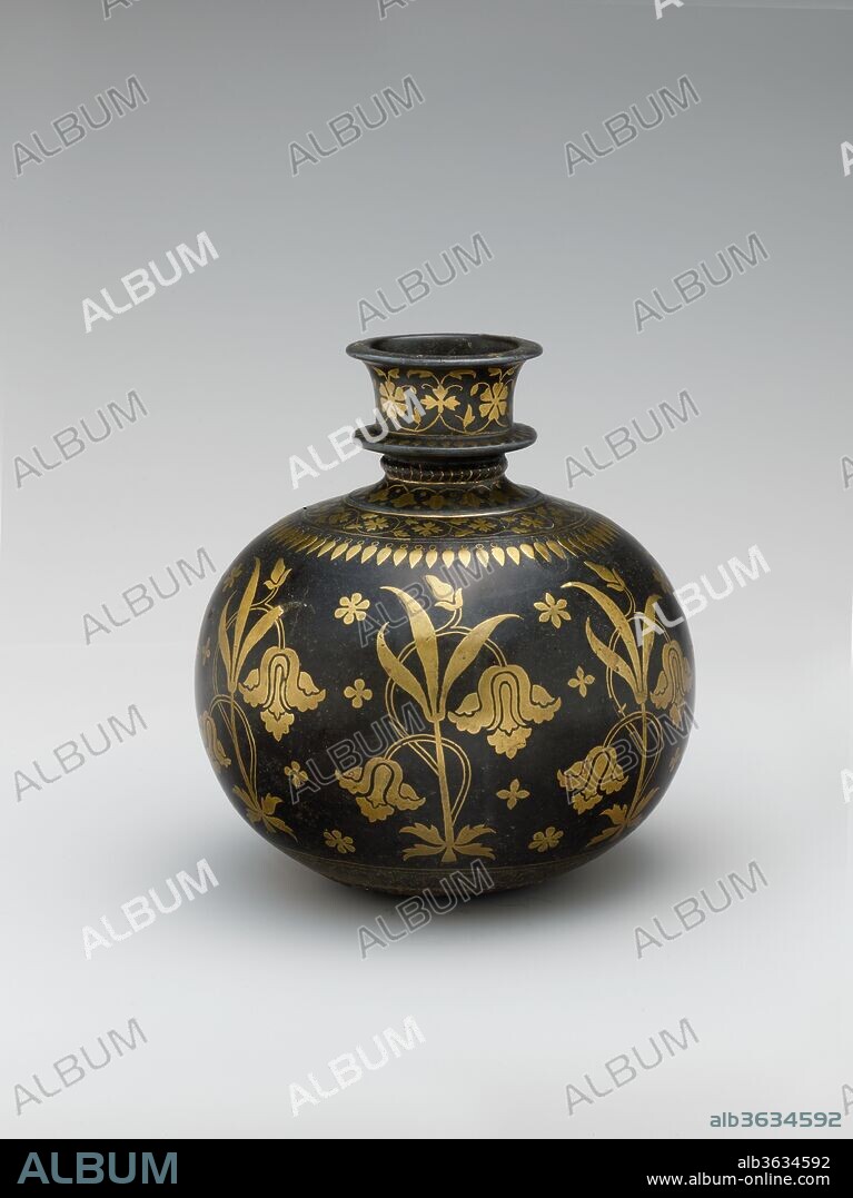 Base for a Water Pipe (Huqqa) with Irises. Dimensions: H. 6 7/8 in. (17.5 cm)
Diam. 6 1/2 in. (16.5 cm). Date: late 17th century.
This huqqa base, with irises and other flowers, would have originally been fitted with a long stem supporting a brazier and a pipe through which the smoker would have inhaled. Many of the known examples of huqqa bases  from the seventeenth and eighteenth centuries were made in the Deccan and decorated with the type of metal inlay known as bidri, in which the base metal of the object is darkened through a chemical process in order to highlight the inlaid metal of the ornament.