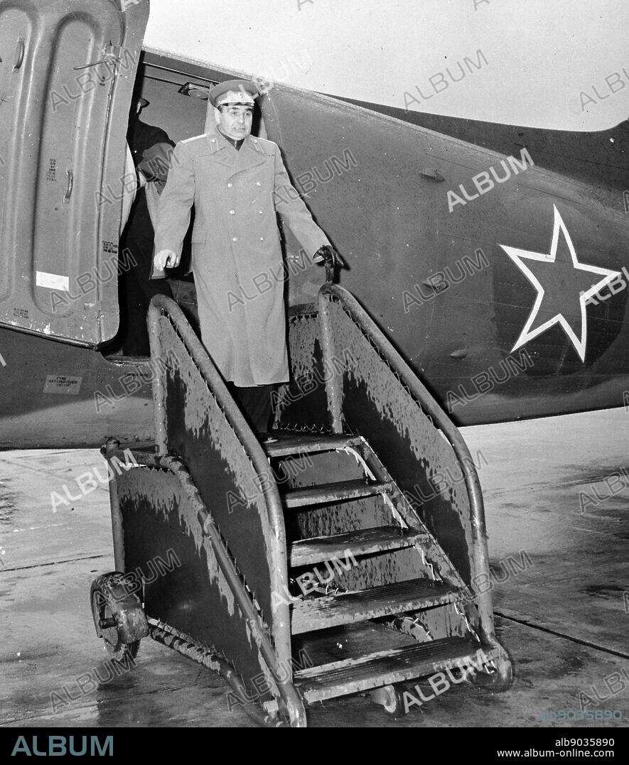 Photograph of Major General Nicholas I. Petrov of the Russian Air Force, bound from Moscow to Washington, stepping from a C-47. Skytrain bearing the red star of Russia at the base of the Alaska wing, Air Transport Command. Dated 1944.