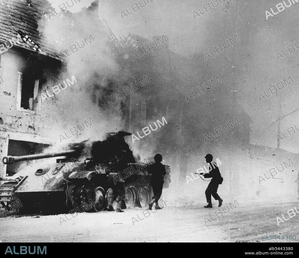 Nazi Tank Crippled in Battle in France: U.S. Troops surround a smoking tiger Mark VI, one of the largest of German tanks, after knocking out the armored vehicle on the Periers front. August 01, 1944. (Photo by U.S. Office of War Information Picture).