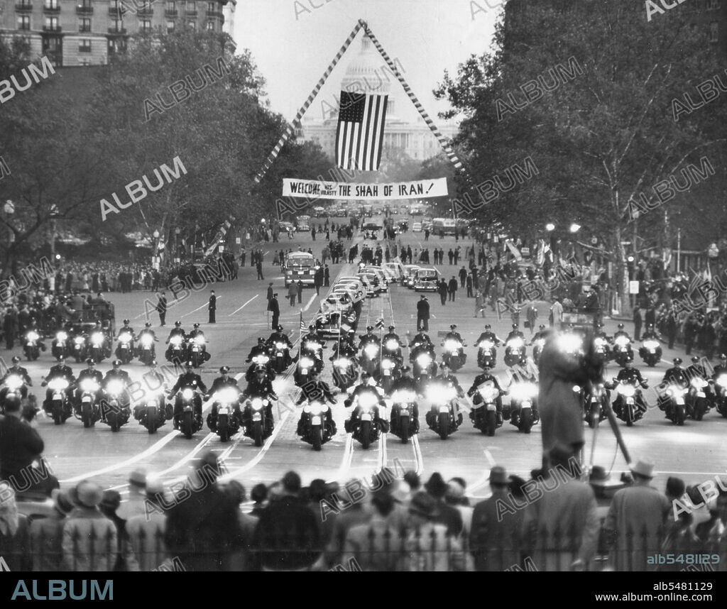 Motorcade with President Harry S. Truman and Mohammad Reza Shah Pahlavi of Iran moves up Pennsylvania Avenue to Blair House. Crowds line the street as police clear the way for the motorcade; welcome banners hang from firetrucks. Washington, DC, Nov 16, 1949.