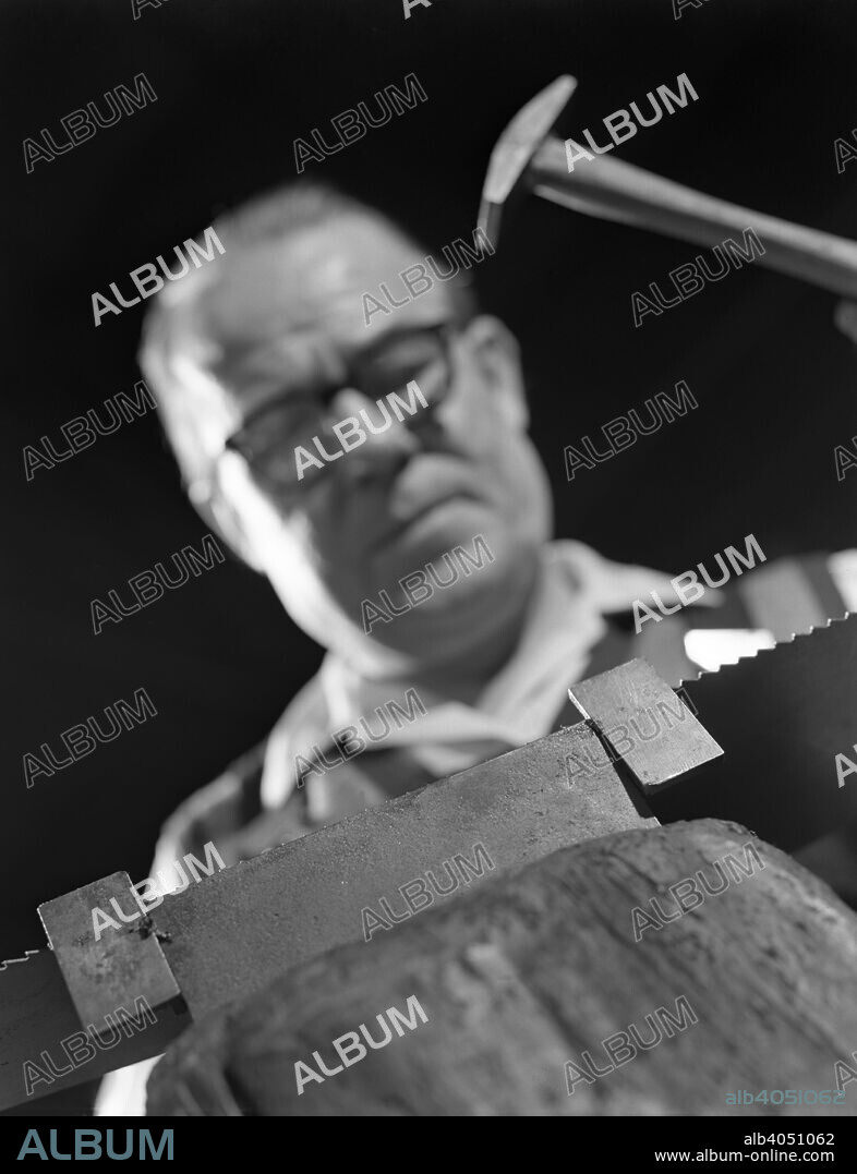 Setting the saw teeth on a hand saw blade, Sheffield, South Yorkshire, 1963. A worker at Slack Sellars & Co Ltd. One of the final processes in the production of a saw, of whatever variety, is to set the saw teeth. In the photograph the saw teeth are set to the correct angle using a saw setting tool. The design of today?s hand saw setting tools remains unchanged.