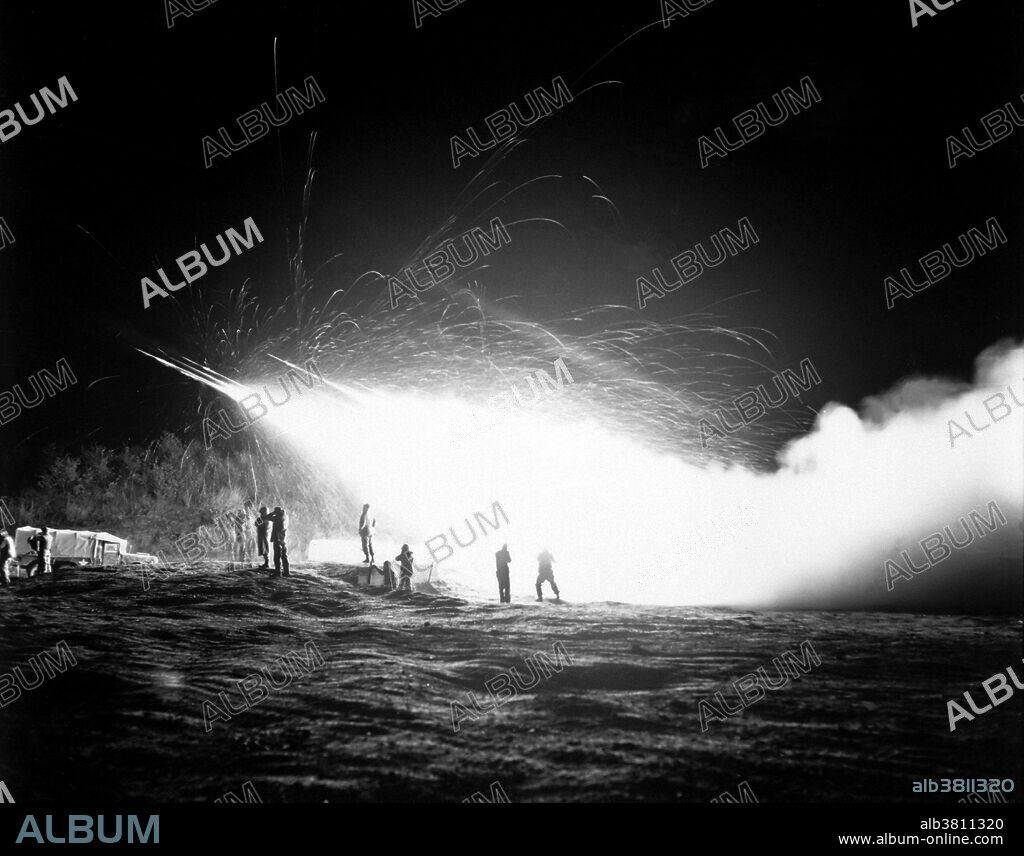 Captioned: "Night view of the First Rocket Battery, 11th Marine Regiment, firing a night mission, somewhere in the Marines front line sector." The 11th Marine Regiment is an artillery regiment of the United States Marine Corps based at Marine Corps Base Camp Pendleton, California. Known as the "Cannon Cockers", the regiment falls under the command of the 1st Marine Division and the I Marine Expeditionary Force. The 11th Marines participated in continued heavy action on the East Central Front throughout 1951, and in March 1952, moved to the Western Front. The 11th was finally able to sail from Korea for the United States and Camp Pendleton in March, 1955. Photograph credited to Master Sergeant Eugene C. Knauft, USMC, April 15, 1953.