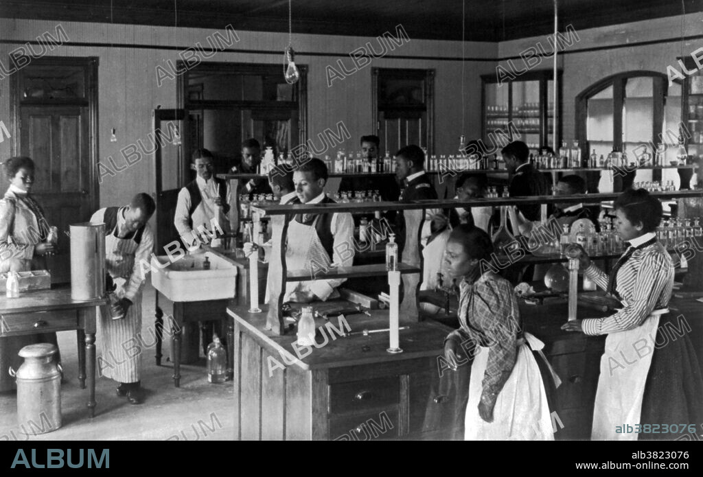 American Indian and African American students in chemistry lab at Hampton Institute, 1899. Hampton University is a historically black university located in Hampton, Virginia, United States. The Hampton Agricultural and Industrial School, later called the Hampton Institute, was founded in 1868 after the American Civil War by the black and white leadership of the American Missionary Association, who were chiefly Congregational and Presbyterian ministers. Their goal was to provide education to freedmen. By 1878 it was also teaching Native Americans. A Hampton-style education became well known as an education that combined cultural uplift with moral and manual training. Photographed by Frances "Fannie" Benjamin Johnston (January 15, 1864 - May 16, 1952) was one of the earliest American female photographers and photojournalists. In 1899 she was commissioned to photograph the buildings and students of the Hampton Normal and Agricultural Institute in order to show its success. This series, documenting the ordinary life of the school, remains as some of her most telling work. It was displayed at the ExposÃ© nÃ¨gre of the Paris Exposition Universelle in 1900.