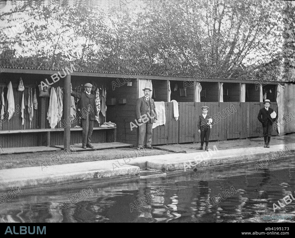 Outdoor swimming pool in the Victorian era with two boys waiting to go for a swim, circa 1900. Magic lantern slide.