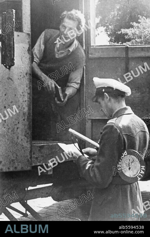 Deutschland / Nachkriegszeit. Polizist bei einer Fahrzeugkontrolle (Fahndung nach Schwarzfahrern). Foto, 1946.