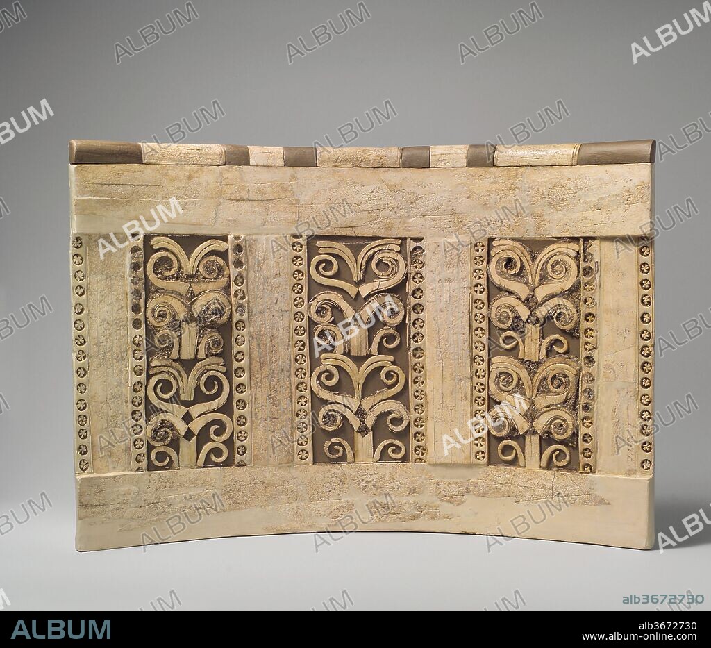 Panel with a tree pattern. Culture: Assyrian. Dimensions: 13 7/8 x 19 5/8 in. (35.2 x 49.8 cm). Date: ca. 8th century B.C..
This piece of ivory furniture was found in a storage room in Fort Shalmaneser, a royal building at Nimrud that was used to store booty and tribute collected by the Assyrians while on military campaign. It was probably part of a bed or couch, judging from the long strips of ivory inlay associated with it, which are also in the Metropolitan Museum's collection (59.107.2a, b). Nineteen other similar furniture pieces, probably chair backs, were stacked in orderly rows in the same storage room. They are rare examples of ancient ivory furniture still in its original form; usually, the wooden frames holding the ivory pieces together have disintegrated by the time they are excavated, but since these chairs and couches were buried after the sack of the Assyrian palaces in 612 B.C., their arrangement was preserved. Set in a modern wood frame, this piece combines plain flat strips of ivory with three vertical rows of plant forms, each bordered on both sides with rows of circles with ivory stars inside. Two additional rows of stars in circles mark the edges, and the top is fitted with a plain curved molding in ivory that originally alternated with another material, perhaps wood or metal, now missing and restored in wood. This piece is the only furniture element from the storeroom decorated with non-figural imagery.
Built by the Assyrian king Ashurnasirpal II, the palaces and storerooms of Nimrud housed thousands of pieces of carved ivory. Most of the ivories served as furniture inlays or small precious objects such as boxes. While some of them were carved in the same style as the large Assyrian reliefs lining the walls of the Northwest Palace, the majority of the ivories display images and styles related to the arts of North Syria and the Phoenician city-states. Phoenician style ivories are distinguished by their use of imagery related to Egyptian art, such as sphinxes and figures wearing pharaonic crowns, and the use of elaborate carving techniques such as openwork and colored glass inlay. North Syrian style ivories tend to depict stockier figures in more dynamic compositions, carved as solid plaques with fewer added decorative elements. However, some pieces do not fit easily into any of these three styles. Most of the ivories were probably collected by the Assyrian kings as tribute from vassal states, and as booty from conquered enemies, while some may have been manufactured in workshops at Nimrud. The ivory tusks that provided the raw material for these objects were almost certainly from African elephants, imported from lands south of Egypt, although elephants did inhabit several river valleys in Syria until they were hunted to extinction by the end of the eighth century B.C.