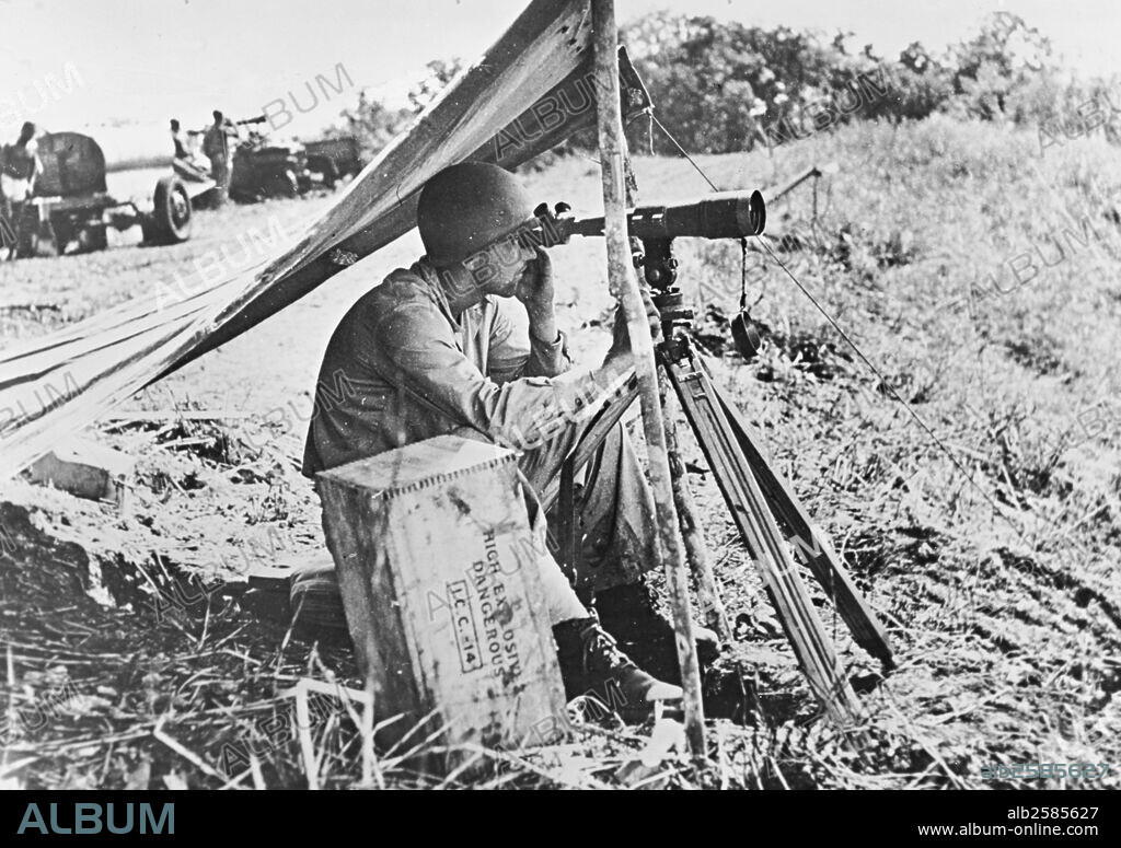 GUADALCANAL.Spotting japanese on Guadalcanal.An American soldier spots japanese positions on Guad. Island in the Solomons.A tarpaulin protects gim from the sun.