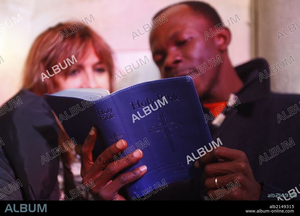 Multiracial couple reading the bible.