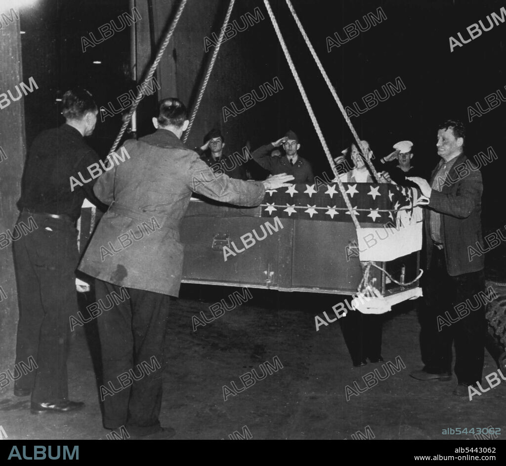 First American War Dead Returns From Korea -- Armed Forces personnel salute as the first casket containing the body of an American (unidentified) war dead is gently lowered by longshore-men from the USS General Randall here tonight. The transport brought 56 other American dead from the Korean battlefields, including the body of Maj. Gen. Bryant E. Moore, former commander of the U.S. Ninth Corps. March 22, 1951. (Photo by AP Wirephoto).