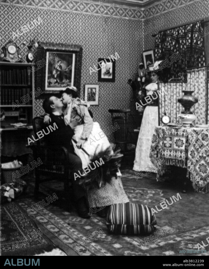 Comical scene showing maid sitting on man's lap kissing him as his wife watches. Depending on the culture and context, a kiss can express sentiments of love, passion, romance, eroticism, sexual attraction, affection, respect, greeting, friendship, peace and good luck, among many others. In some situations a kiss is a ritual, formal or symbolic gesture indicating devotion, respect, or sacrament. Kissing has been recorded for at least the last five millennia. The study of kissing started some time in the 19th century and is called Philematology. Cropped stereograph by the American Stereoscopic Company, manufacturers and publishers, 1907.