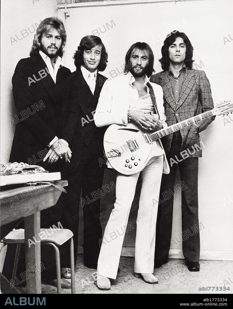 The Bee Gees posing with a guitar. The Bee Gees musical group posing with a guitar. The band is composed by the three English brothers and musicians Barry, Robin and Maurice Gibb with the Australian drummer Geoff Bridgford. Rome, 1970s.